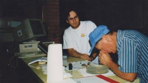 Two men looking at telescope parts - 1990