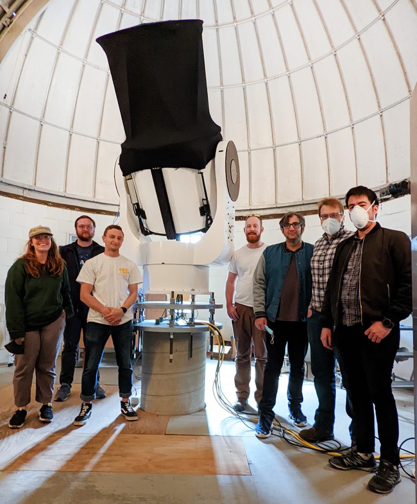 Team standing in front of telescope