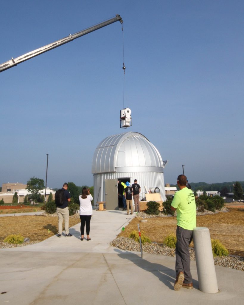 Crane placing telescope into dome
